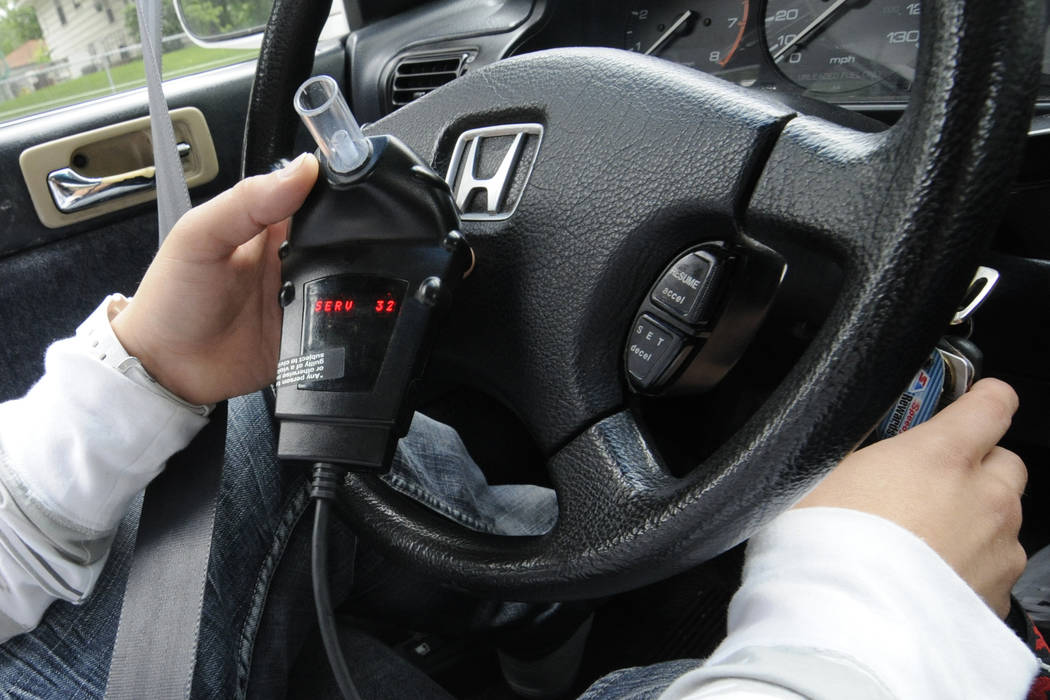 An interlock ignition system requires the driver to blow into a tube to prove they are sober before starting the car. (Jim Mone/AP)