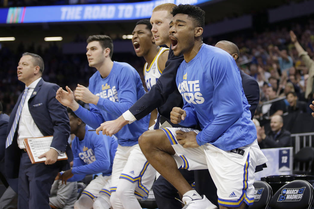 Members of the UCLA basketball team celebrate after the Bruins scored against Cincinnati during the second half of a second-round game of the NCAA men's college basketball tournament in Sacramento ...