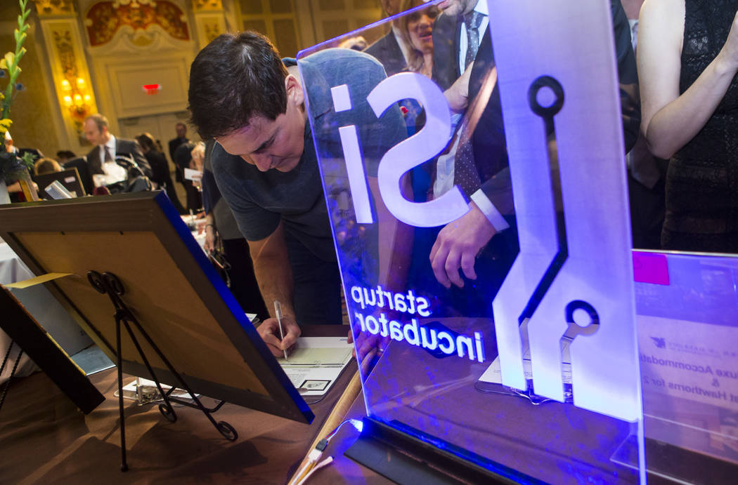 Entrepreneur Mark Cuban, left, places a bid at the silent auction during the Adelson Educational Campus' 13th annual In Pursuit of Excellence Gala at The Venetian hotel-casino in Las Vegas on Sund ...