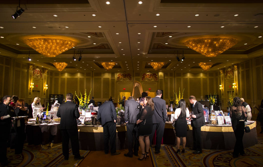 Attendees look through silent auction items during the Adelson Educational Campus' 13th annual In Pursuit of Excellence Gala at The Venetian hotel-casino in Las Vegas on Sunday, March 26, 2017. (C ...