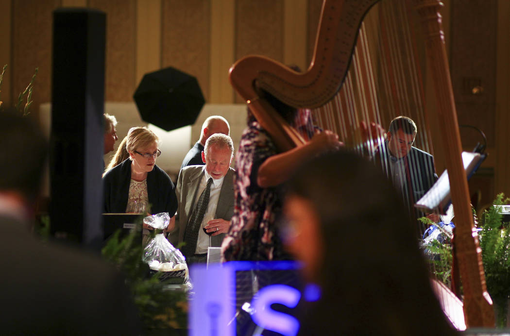 Attendees look through silent auction items during the Adelson Educational Campus' 13th annual In Pursuit of Excellence Gala at The Venetian hotel-casino in Las Vegas on Sunday, March 26, 2017. (C ...