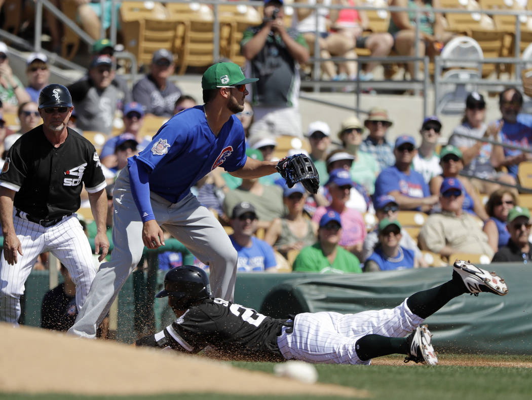 Chicago White Sox's Tyler Saladino slides safe into third as Chicago Cubs' Kris Bryant takes the throw during the second inning of a spring training baseball game Friday, March 17, 2017, in Phoeni ...