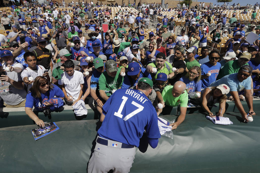 Chicago Cubs' Kris Bryant signs autographs during a spring training baseball game against the Chicago White Sox, Friday, March 17, 2017, in Phoenix. (AP Photo/Darron Cummings)