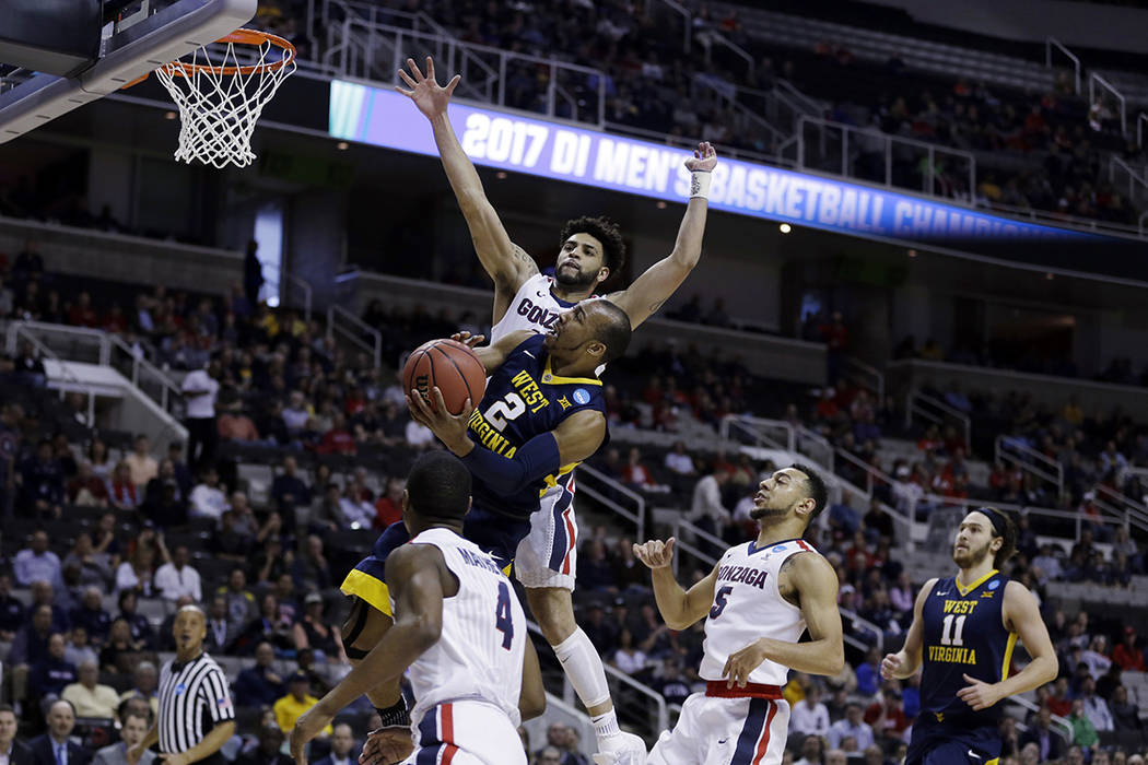 West Virginia guard Jevon Carter (2) drives to the basket as Gonzaga guard Josh Perkins, top, defends during the first half of an NCAA Tournament college basketball regional semifinal game Thursda ...