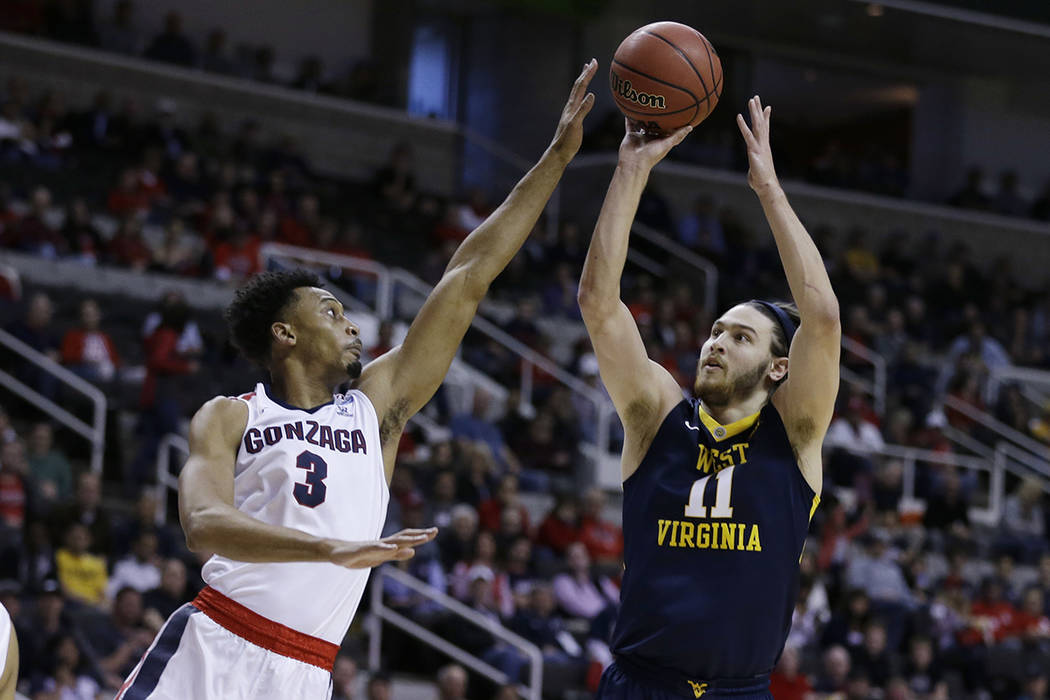 West Virginia's Nathan Adrian (11) shoots over Gonzaga forward Johnathan Williams (3) during the first half of an NCAA Tournament college basketball regional semifinal game Thursday, March 23, 201 ...