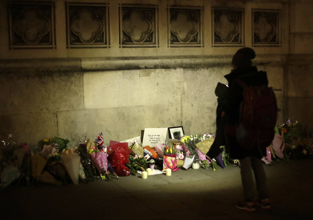 People lay flowers as a tribute to the victims of Wednesday's attack outside the Houses of Parliament, after police cordon was removed in central London, Thursday March 23, 2017. (Matt Dunham/AP)