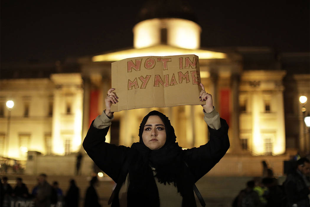 A woman holds up a sign at a vigil for the victims of Wednesday's attack, at Trafalgar Square in London, Thursday, March 23, 2017. (Matt Dunham/AP)