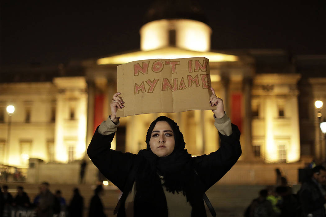 A woman holds up a sign at a vigil for the victims of Wednesday's attack, at Trafalgar Square in London, Thursday, March 23, 2017. (Matt Dunham/AP)