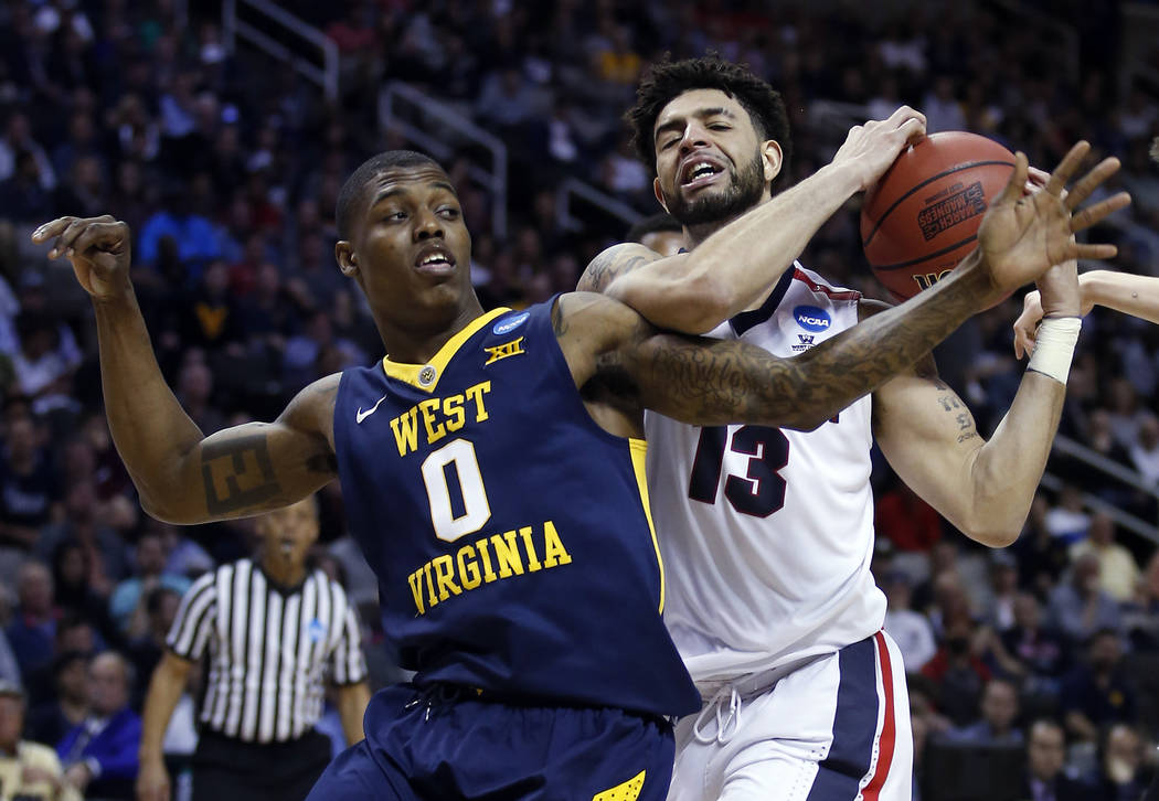 Gonzaga guard Josh Perkins (13) grabs a rebound next to West Virginia guard Teyvon Myers during the second half of an NCAA Tournament college basketball regional semifinal game Thursday, March 23, ...