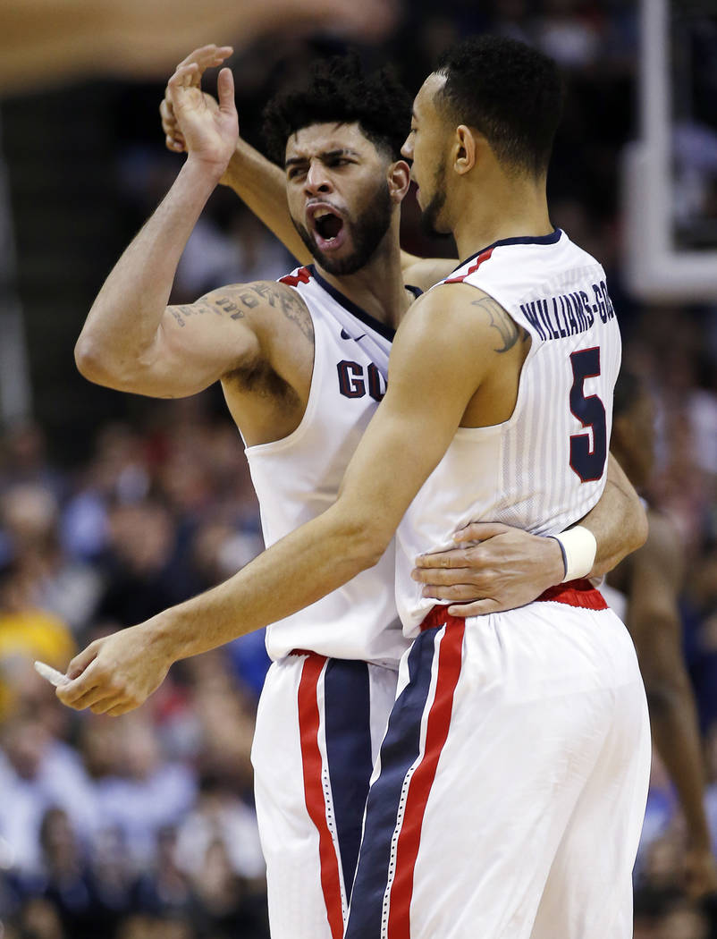 Gonzaga guard Josh Perkins, left, celebrates with teammate Nigel Williams-Goss, right, after a win over West Virginia during the second half of an NCAA Tournament college basketball regional semif ...