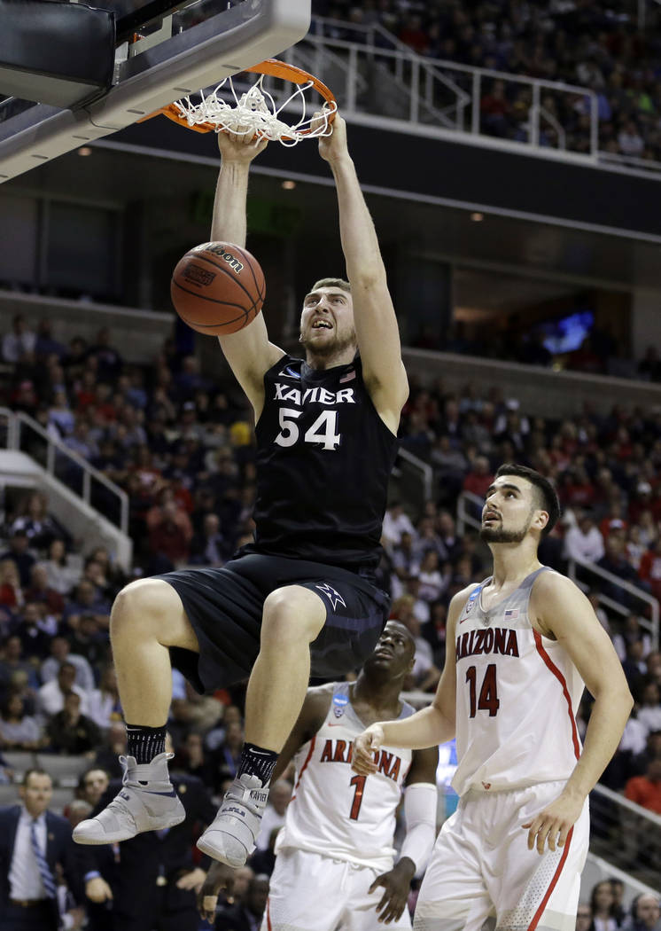 Xavier's Sean O'Mara (54) dunks past Arizona center Dusan Ristic (14) during the second half of an NCAA Tournament college basketball regional semifinal game Thursday, March 23, 2017, in San Jose, ...