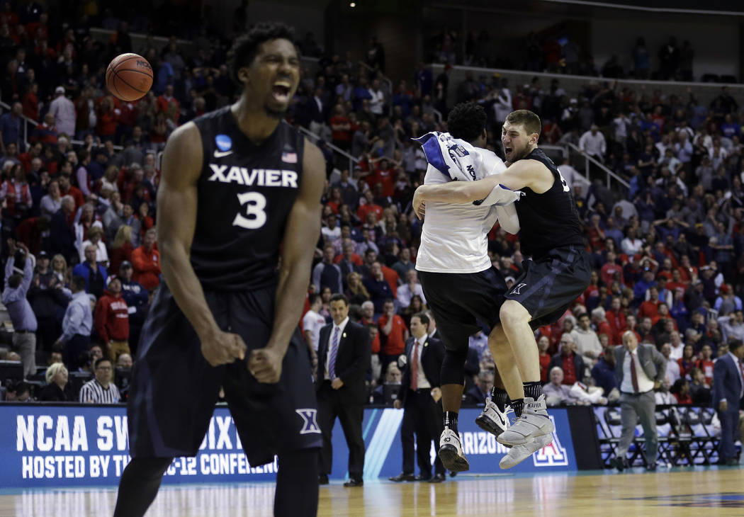 Xavier players including Sean O'Mara, right, and Quentin Goodin (3) celebrate after beating Arizona during an NCAA Tournament college basketball regional semifinal game Thursday, March 23, 2017, i ...