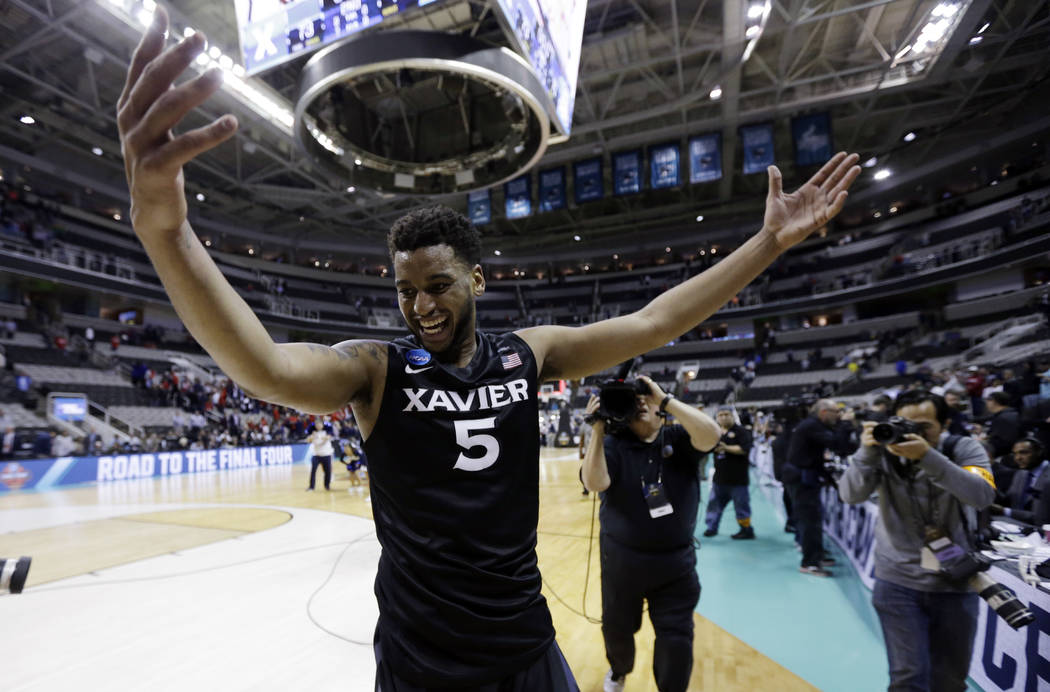 Xavier players including Sean O'Mara, right, and Quentin Goodin (3) celebrate after beating Arizona during an NCAA Tournament college basketball regional semifinal game Thursday, March 23, 2017, i ...