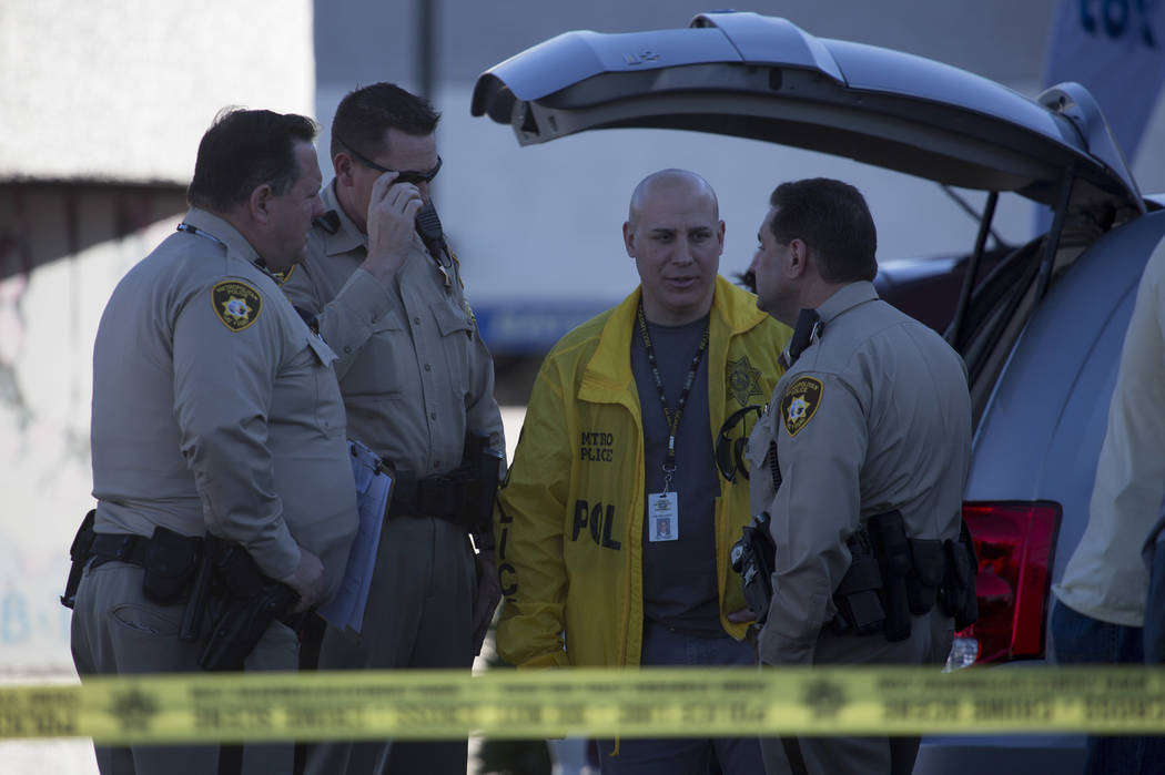 Officers gather in a parking lot outside a Rapid Cash, on W. Flamingo Road near Jones Boulevard, in Las Vegas on Friday, March 24, 2017. (Bridget Bennett/Las Vegas Review-Journal) @bridgetkbennett