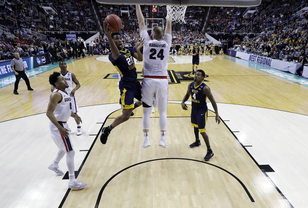West Virginia forward Brandon Watkins (20) drives to basket as Gonzaga center Przemek Karnowski (24) defends during the first half of an NCAA Tournament college basketball regional semifinal game ...
