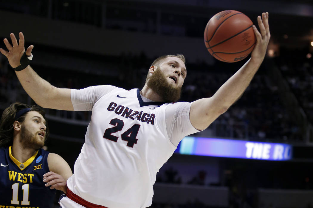 Gonzaga center Przemek Karnowski (24) grabs a rebound next to West Virginia forward Nathan Adrian (11) during the first half of an NCAA Tournament college basketball regional semifinal game Thursd ...