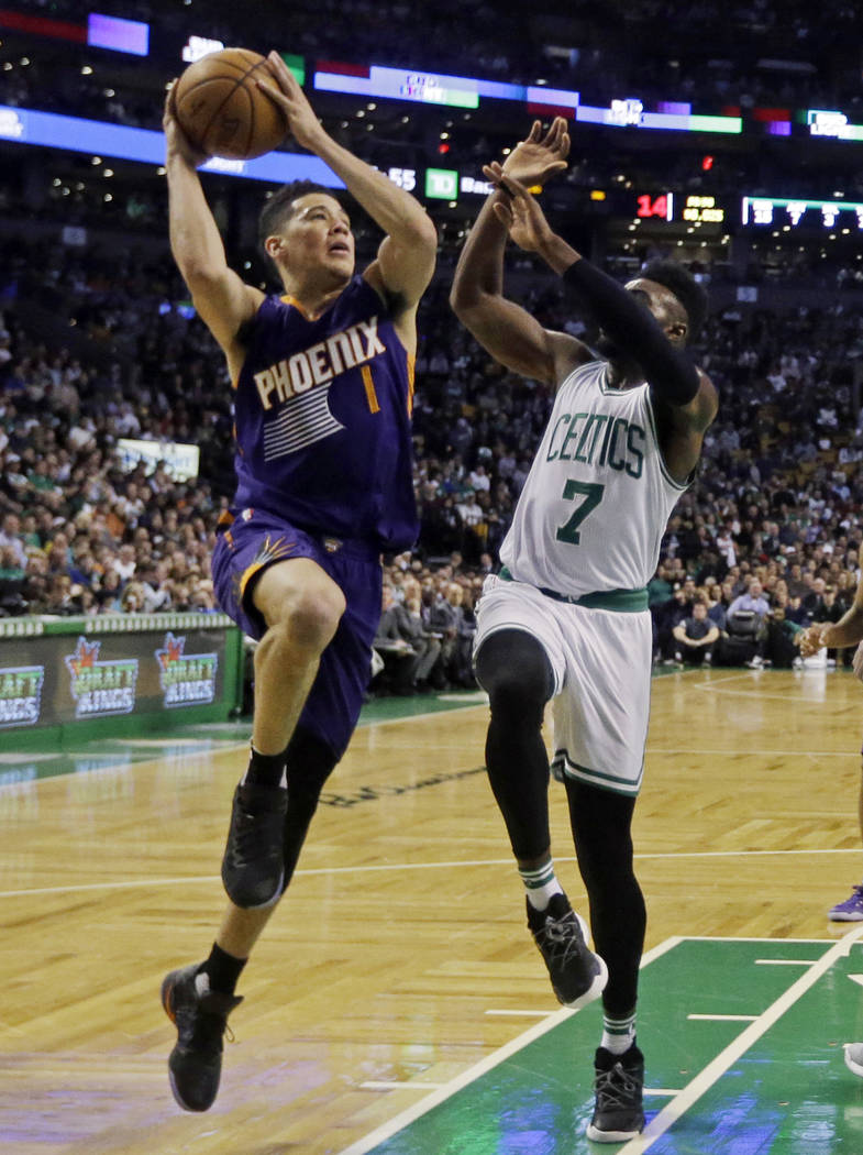 Phoenix Suns guard Devin Booker (1) goes up for a shot against Boston Celtics forward Jaylen Brown (7) during the first quarter of an NBA basketball game, Friday, March 24, 2017, in Boston. Booker ...