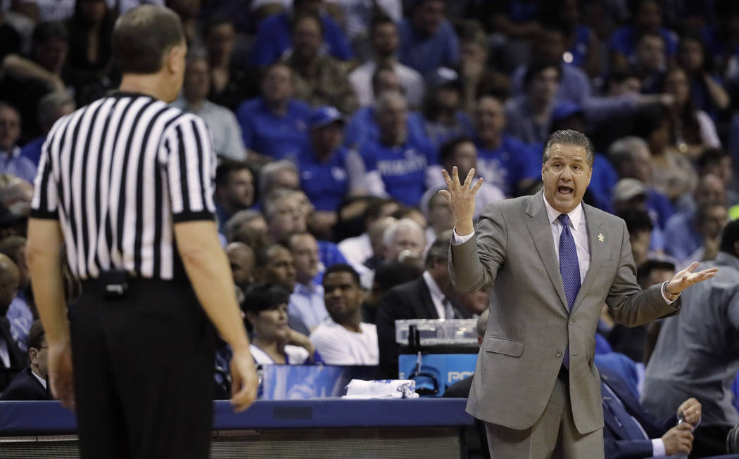 Kentucky head coach John Calipari speaks with an official in the first half of an NCAA college basketball tournament South Regional semifinal game against UCLA, Friday, March 24, 2017, in Memphis, ...