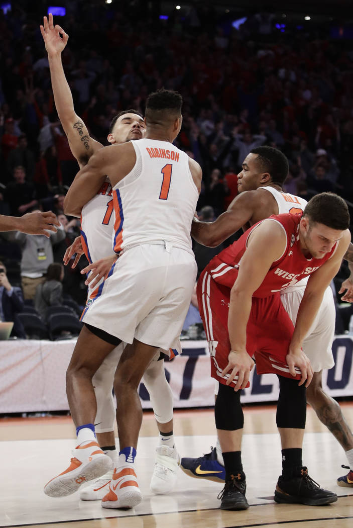 Florida forward Devin Robinson (1) hugs guard Chris Chiozza (11) after Chiozza hit the game winning shot in overtime against Wisconsin at an East Regional semifinal game of the NCAA men's college  ...