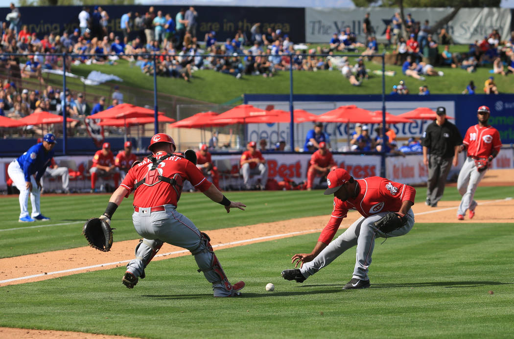Cincinnati Reds pitcher Sandy Lugo (90) and catcher Tucker Barnhart (16) field a ball during a game between the Chicago Cubs and the Cincinnati Reds at Cashman Field in Las Vegas on Sunday, March ...