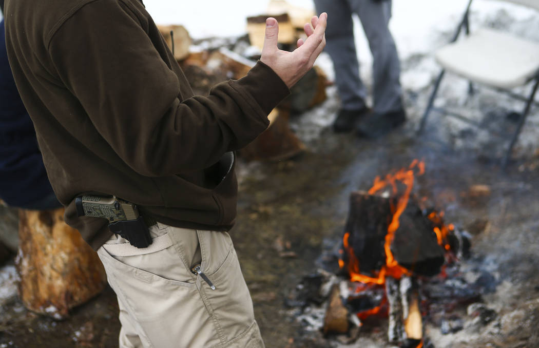Anti-government protester Jon Ritzheimer talks by a fire while guarding the entrance of the Malheur National Wildlife Refuge headquarters, which the group is occupying, near Burns, Ore. on Thursda ...