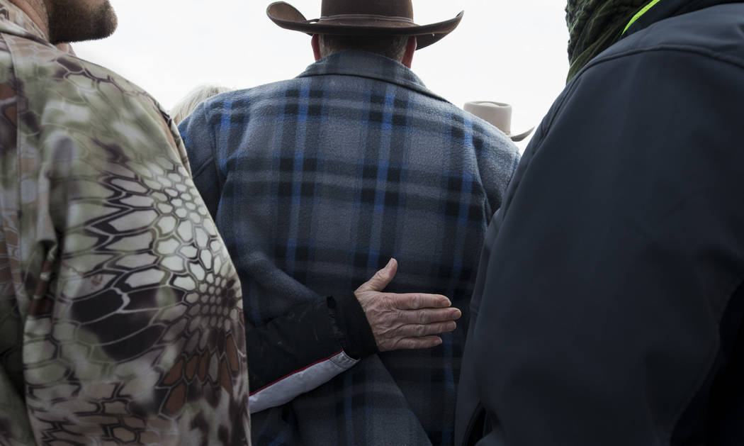 Ammon Bundy, center, is comforted by Shawna Cox as LaVoy Finicum, an Arizona rancher, not pictured, speaks with reporters at a news conference by the entrance of Malheur National Wildlife Refuge n ...