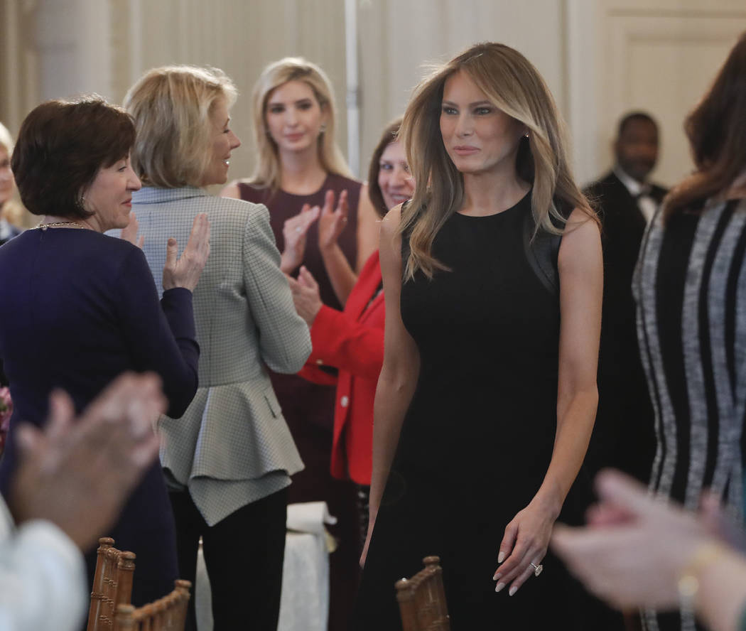 First lady Melania Trump walks into the State Dining room of the White House in Washington, Wednesday, March 8, 2017, where she hosted a luncheon in honor of International Women's Day. Also in att ...