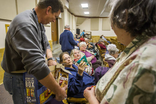 Southern Baptist Disaster Relief Chaplain Jeff Thompson passes bags of chips to, from left to right, Suzanne Morgan, Carol Shaylor and Linda Nimmo Monday, March 6, 2017, inside an evacuation cente ...