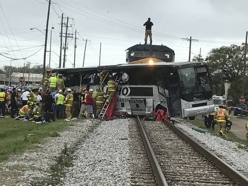Biloxi firefighters assist injured passengers after their charter bus collided with a train in Biloxi, Miss., Tuesday, March 7, 2017.  Biloxi city spokesman Vincent Creel says emergency responders ...
