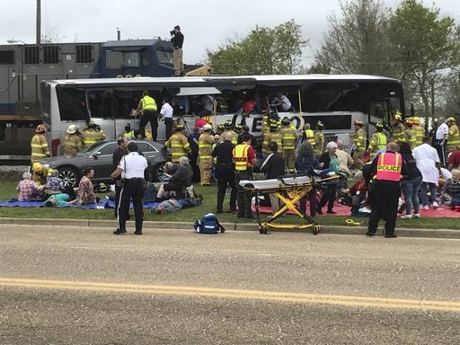 Emergency personnel assist injured passengers after their charter bus collided with a train in Biloxi, Miss., Tuesday, March 7, 2017.  Biloxi city spokesman Vincent Creel says emergency responders ...