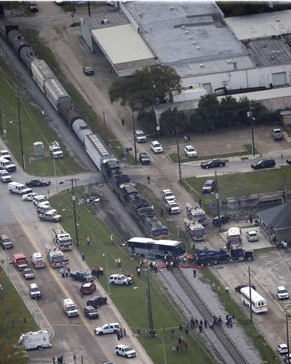Responders works the scene where a train hit a bus in Biloxi, Miss., Tuesday, March 7, 2017. A freight train smashed into a charter bus in Biloxi, Mississippi, on Tuesday, pushing the bus 300 feet ...