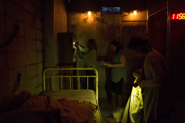Participators search high and low for clues, hints and other keys that may help them escape at The Basement Escape Room in Las Vegas. (Bridget Bennett/Las Vegas Review-Journal) @bridgetkb