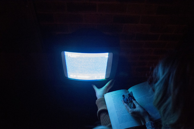 Participants use light from a screen to search books for clues to escape at The Basement Escape Room in Las Vegas. (Bridget Bennett/Las Vegas Review-Journal) @bridgetkb