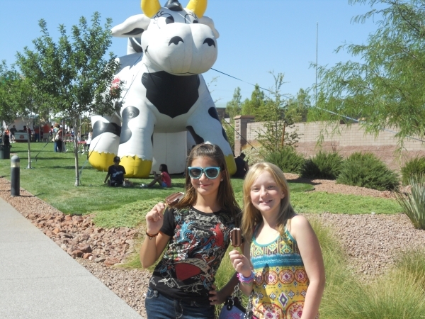 Two girls enjoy free ice cream in front of the inflatable Meadow Gold cow at last year‘s Sunny 106.5 Ice Cream Sunday. Meadow Gold will provide the frozen treats on Sept. 27 at the new Huckl ...