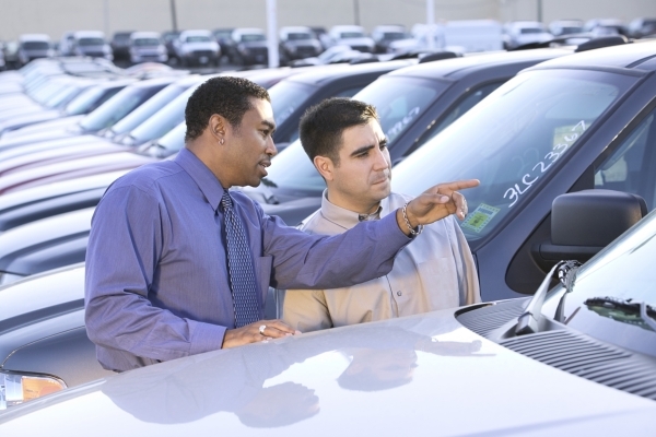 Salesman and man at car dealership