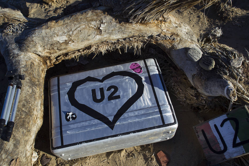 A briefcase with tributes and memorabilia from fans of rock band U2 sits with the fallen tree that appeared in the band's 1987 album "The Joshua Tree" outside of Death Valley Nat ...