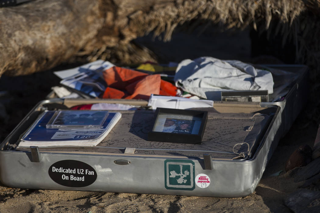 A briefcase with tributes and memorabilia from fans of rock band U2 sits with the fallen tree that appeared in the band's 1987 album "The Joshua Tree" outside of Death Valley Nat ...