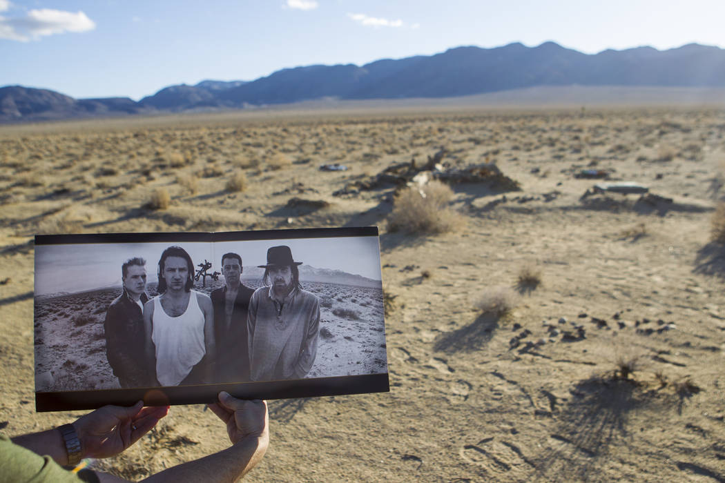 The remains of the tree featured in the album artwork of U2's 1987 album &quot;The Joshua Tree&quot; is shown with a copy of the album outside of Death Valley National Park along Californi ...