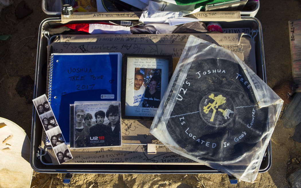 A briefcase with tributes and memorabilia from fans of rock band U2 sits with the fallen tree that appeared in the band's 1987 album "The Joshua Tree" outside of Death Valley Nat ...