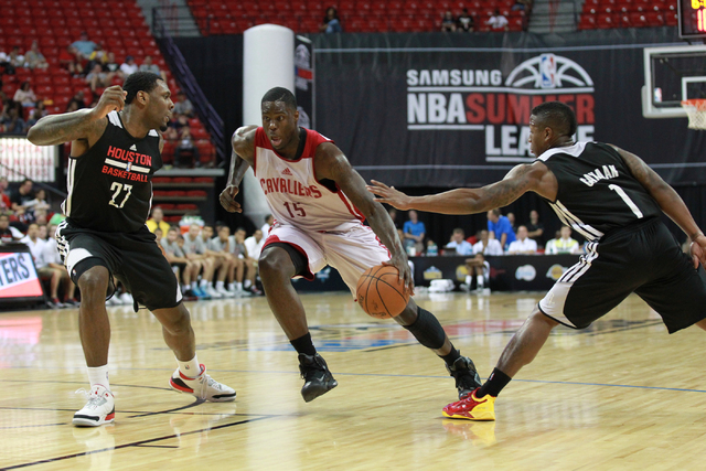Cleveland's Anthony Bennett (15) looks to drive the ball past Houston's Tarik Black (27) and Isaiah Canaan (1) during an NBA Summer League game at the Thomas & Mack Center in Las Vegas on Thur ...
