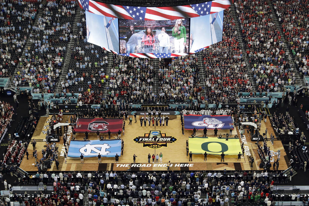 Fans stand as they observe the national anthem before the first half in the semifinals of the Final Four NCAA college basketball tournament between South Carolina and Gonzaga, Saturday, April 1, 2 ...
