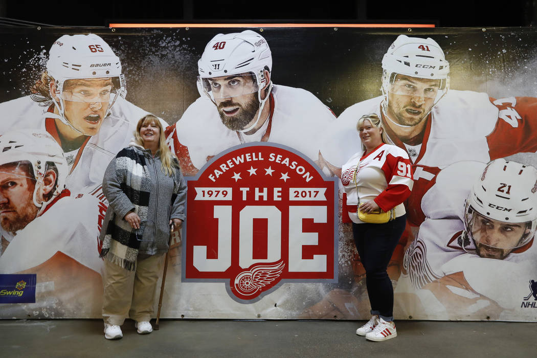 In this Sunday, March 26, 2017, photo, Detroit Red Wings fans pose with a farewell sign to Joe Louis Arena before an NHL hockey game, in Detroit. Joe Louis Arena will be the home of the Red Wings  ...