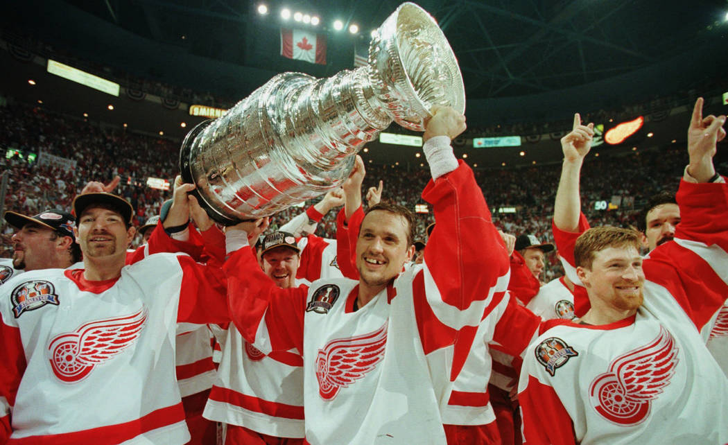 FILE - In this June 7, 1997, file photo, Detroit Red Wings' Tim Taylor, from left, Steve Yzerman and Doug Brown celebrate with the Stanley Cup after beating the Philadelphia Flyers 2-1 at Joe Loui ...
