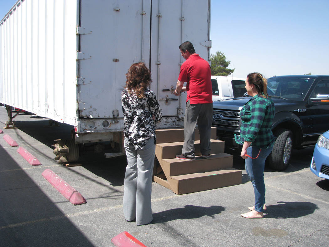 Assistant principal Derek Stafford of Las Vegas High School opens the tractor trailer that will be transformed into a distribution center for supplies for the homeless population of the school. Fr ...
