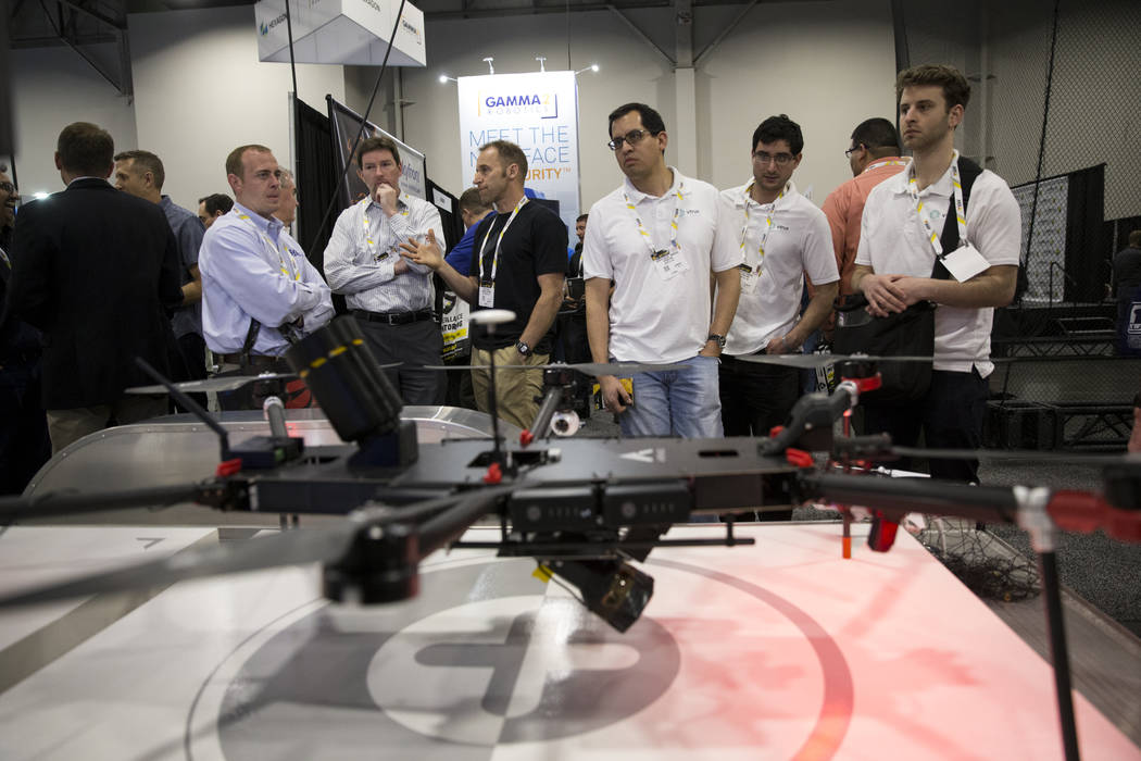 Attendees visit the Airspace booth which displayed drones capable of removing drones from the sky during on command during the International Security Conference & Exposition at the Sands Expo ...