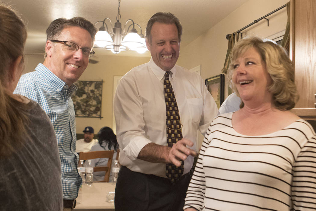 Mayor of North Las Vegas John Lee, center, with his wife Leana Lee, right,  laughs as he waits for election results in the home of North Las Vegas City  Council nominee Scott