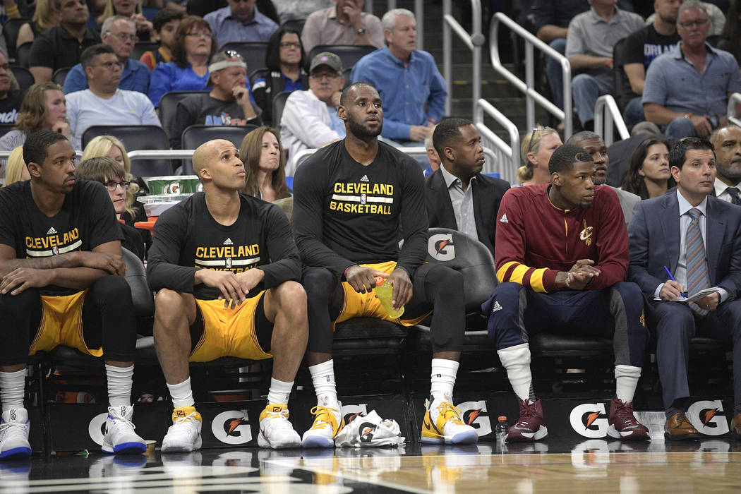 Cleveland Cavaliers forward LeBron James, center, rests on the bench during the first half of an NBA basketball game against the Orlando Magic in Orlando, Fla., Saturday, March 11, 2017. (AP Photo ...