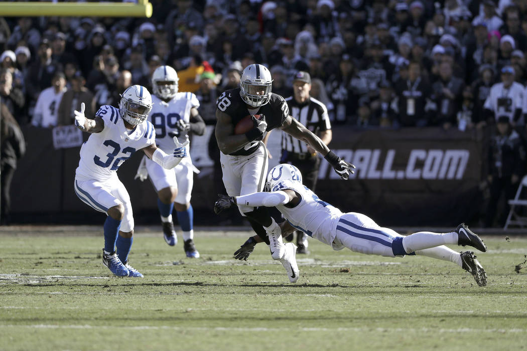 Oakland Raiders running back Latavius Murray (28) runs against Indianapolis Colts cornerback Vontae Davis (21) during the first half of an NFL football game in Oakland, California, on Dec. 24, 201 ...