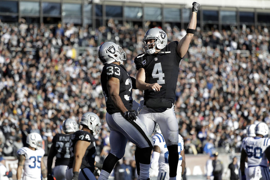 Oakland Raiders running back DeAndre Washington (33) celebrates after running for a touchdown with quarterback Derek Carr (4) during the second half of an NFL football game against the Indianapoli ...