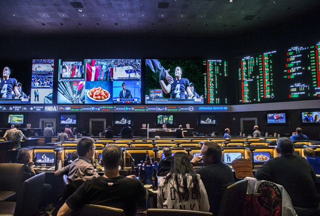 Customers watch an interview with Oakland Raiders quarterback Derek Carr at The Race & Sports Book at Green Valley Ranch on Nov. 14, 2016, in Henderson. (Benjamin Hager/Las Vegas Review-Journal)